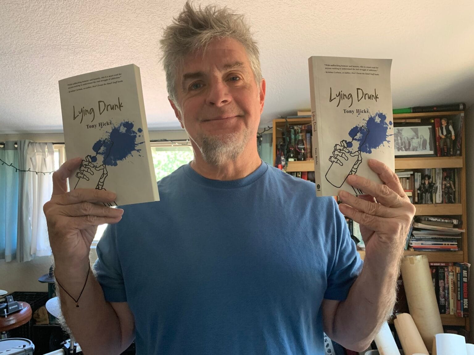 Author Tony Hicks holds up 'Lying Drunk' book
